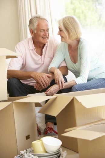 Senior Couple Moving Home And Packing Boxes