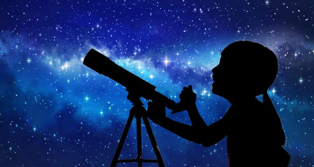 Silhouette Of Little Girl Looking Through A Telescope